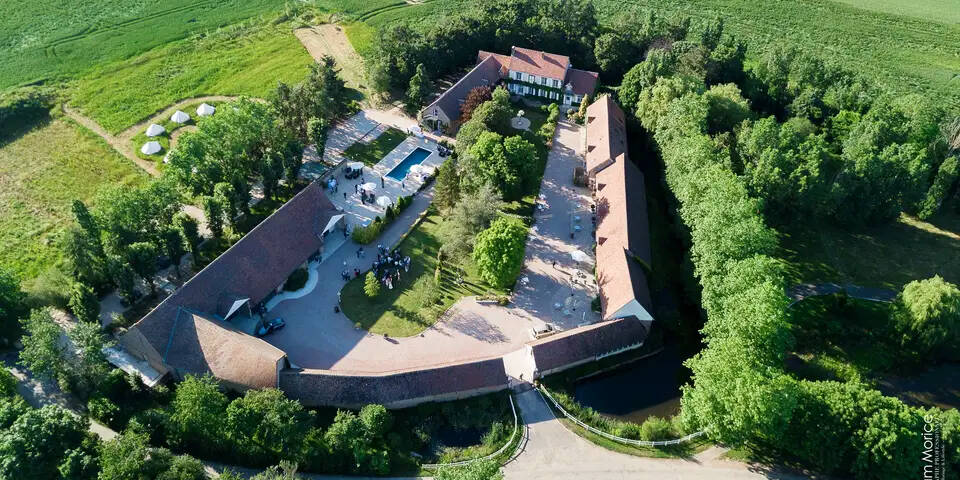 Vue aérienne du Domaine de Vaujoly entouré de verdure, avec des espaces de réception et un parc, idéal pour des événements comme des mariages ou séminaires.